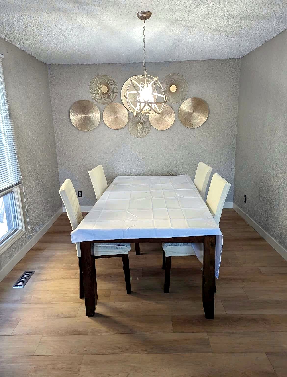 Renovated dining and living space with new wide-plank flooring in a St. Albert area home